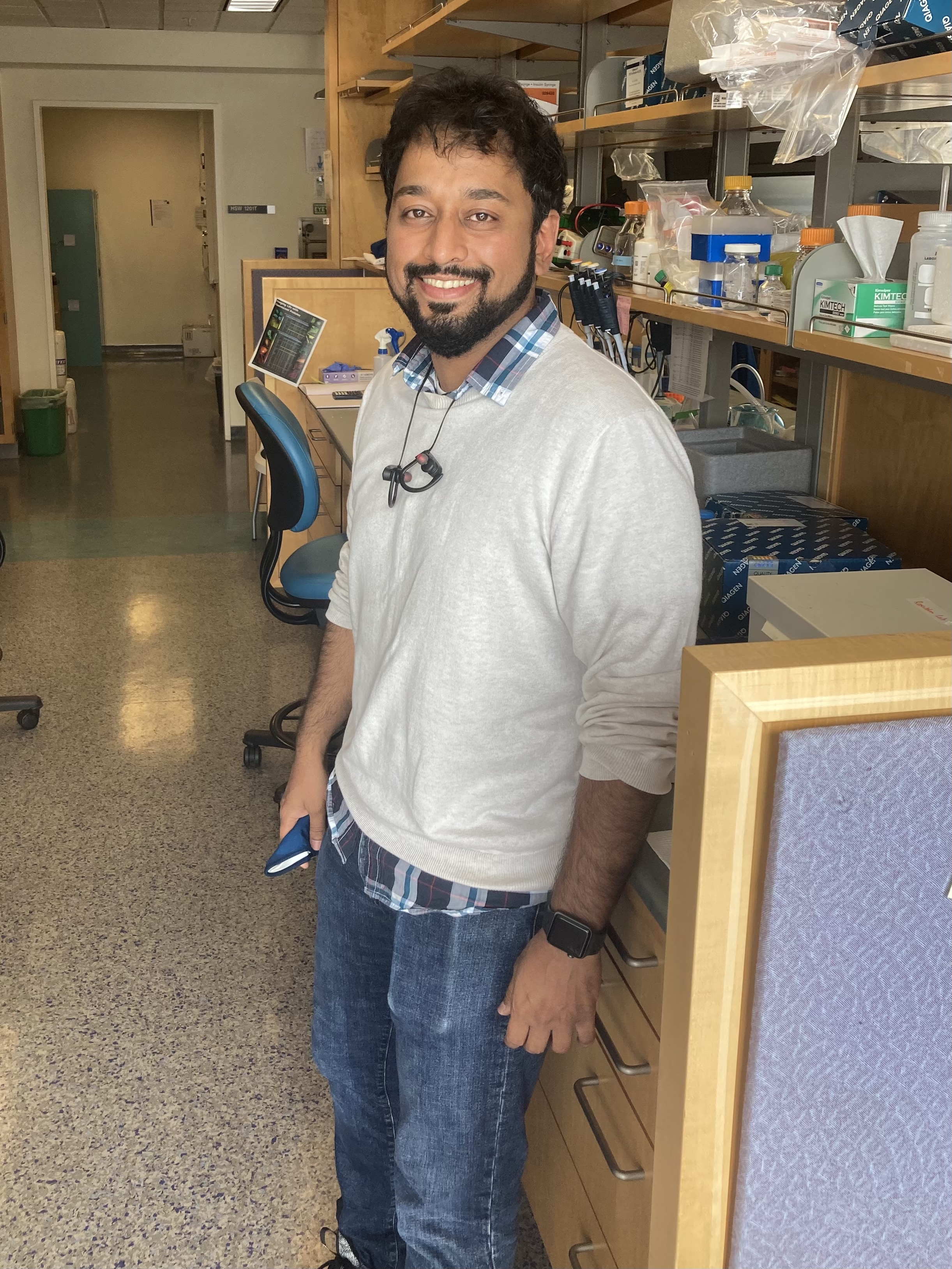 Miqdad smiling by a lab bench